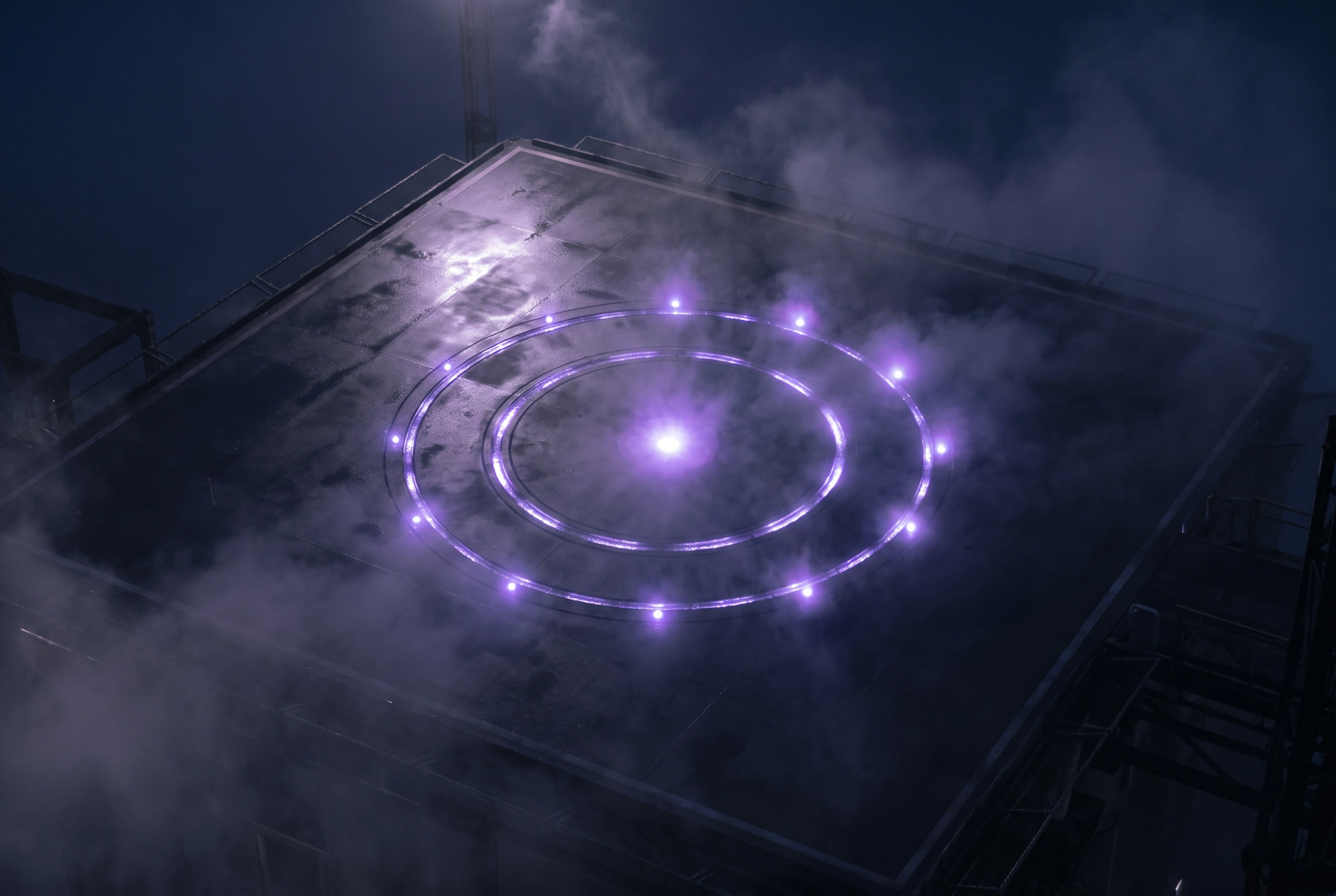 Alvo circular de pouso com anéis de luz roxa.